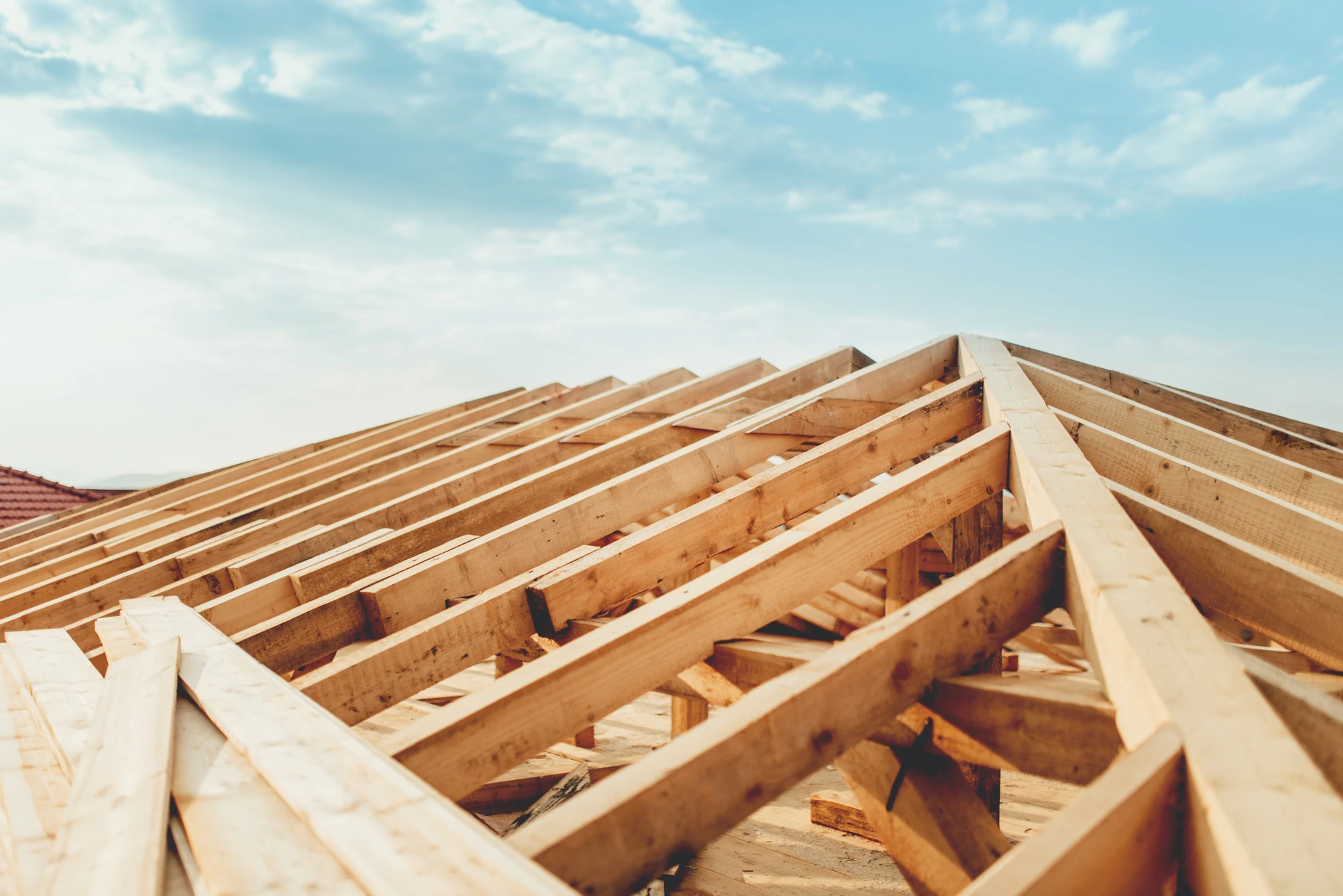 Chantier de construction résidentielle en cours avec charpente bois apparente et échafaudage métallique